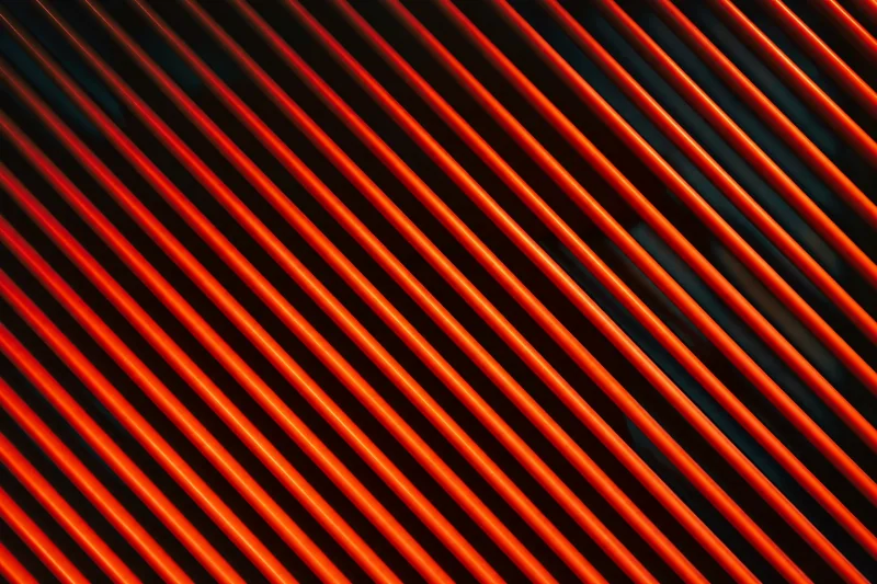 Orange diagonal illuminated ribs against deep dark teal